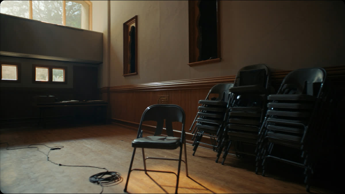 Stacked folding chairs in an empty church hall before a service